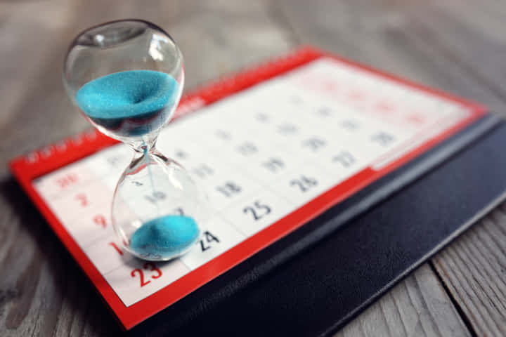 Hour glass on calendar concept for time slipping away for important appointment date, schedule and deadline
