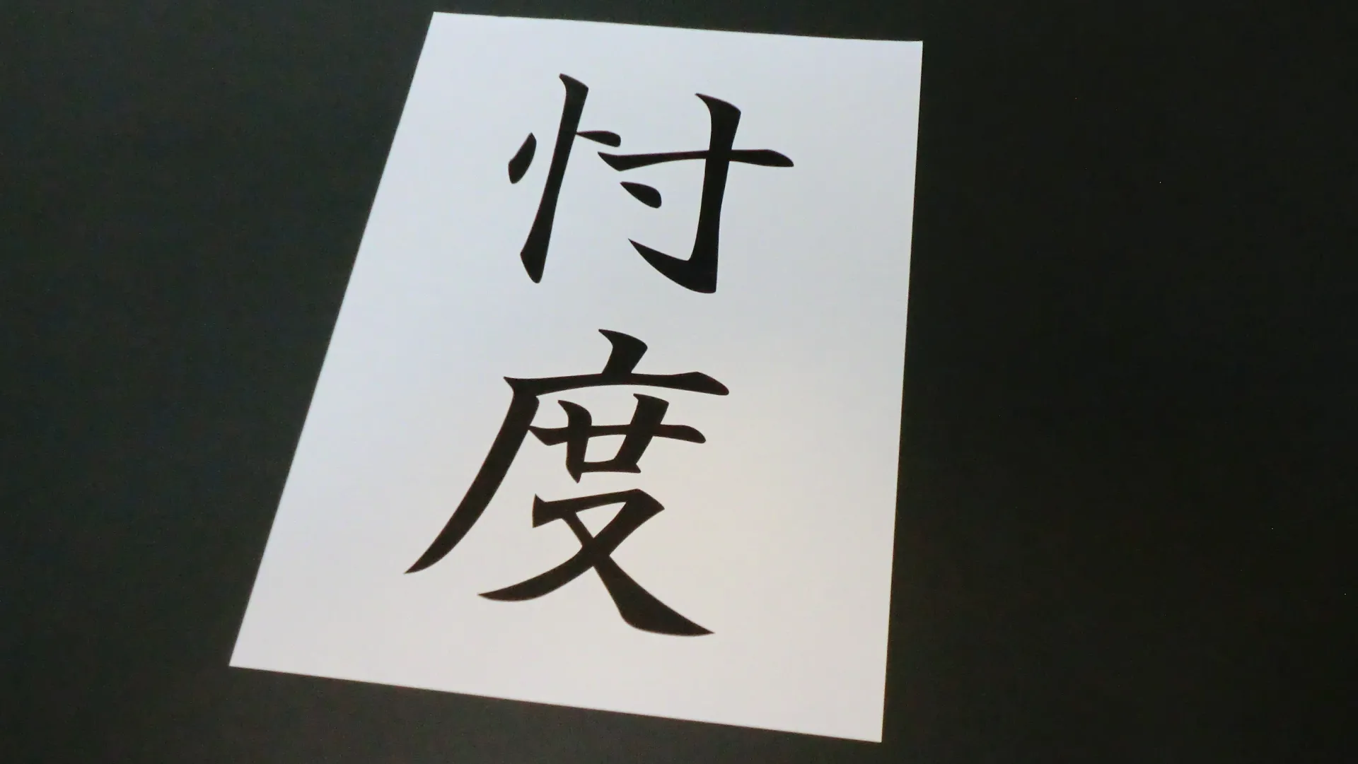 A piece of paper with "忖度" written on it with a feeling