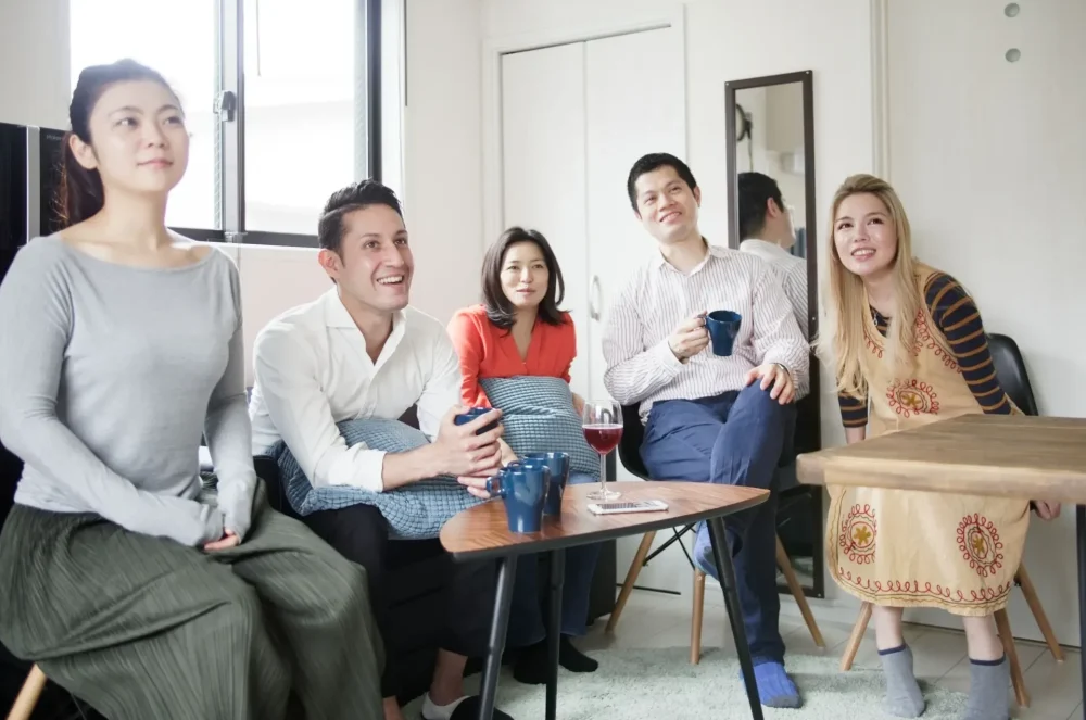 Estrangeiros e japoneses relaxando em uma casa compartilhada japonesa.