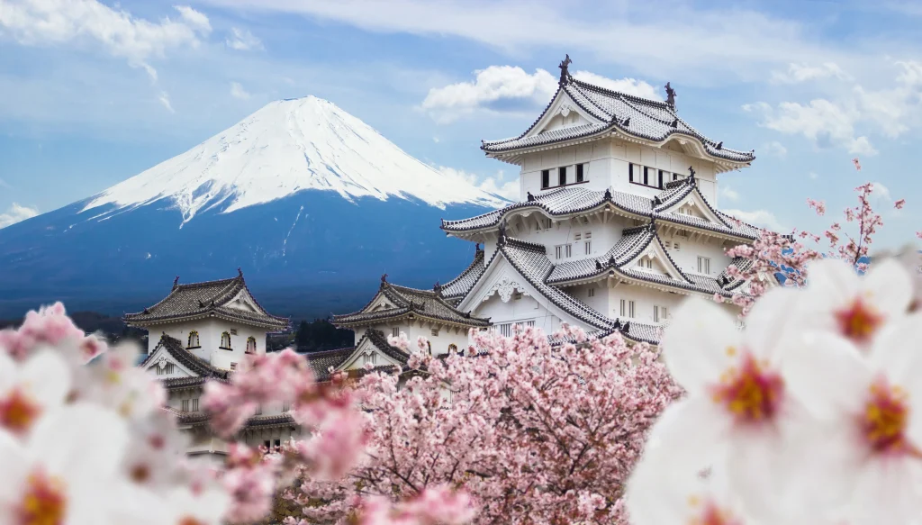 O Castelo de Himeji e as flores de cerejeira em plena floração, tendo como pano de fundo o Monte Fuji, no Japão.