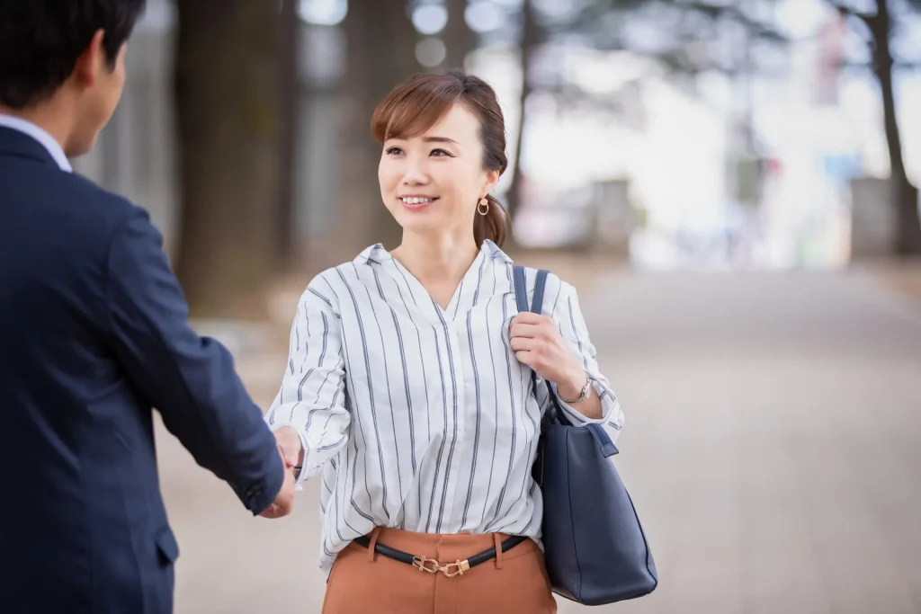 Woman shaking hands with "よろしくお願いします".