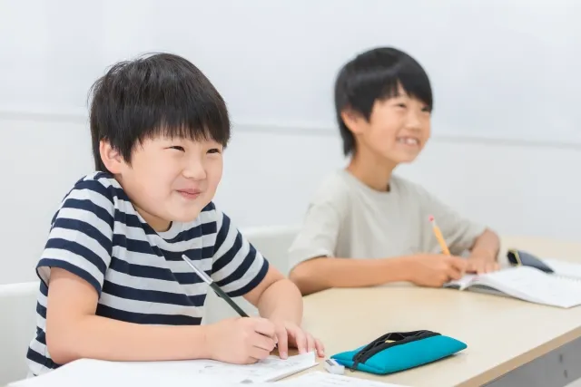 日本の塾で授業を受けている男子学生2人