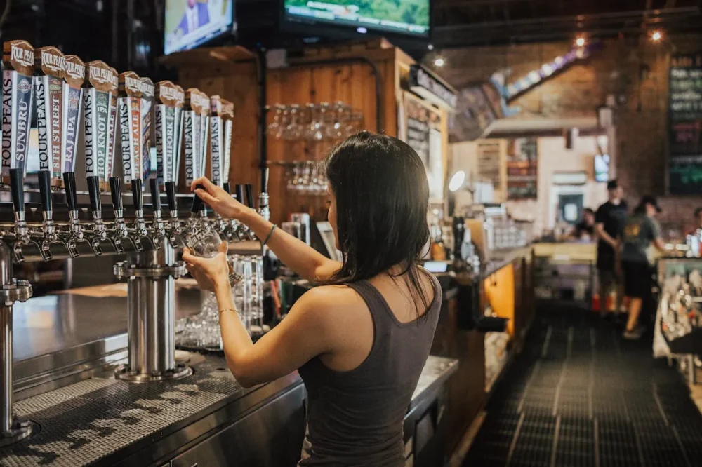 Vista traseira de uma mulher estrangeira trabalhando em um bar em Yokohama.